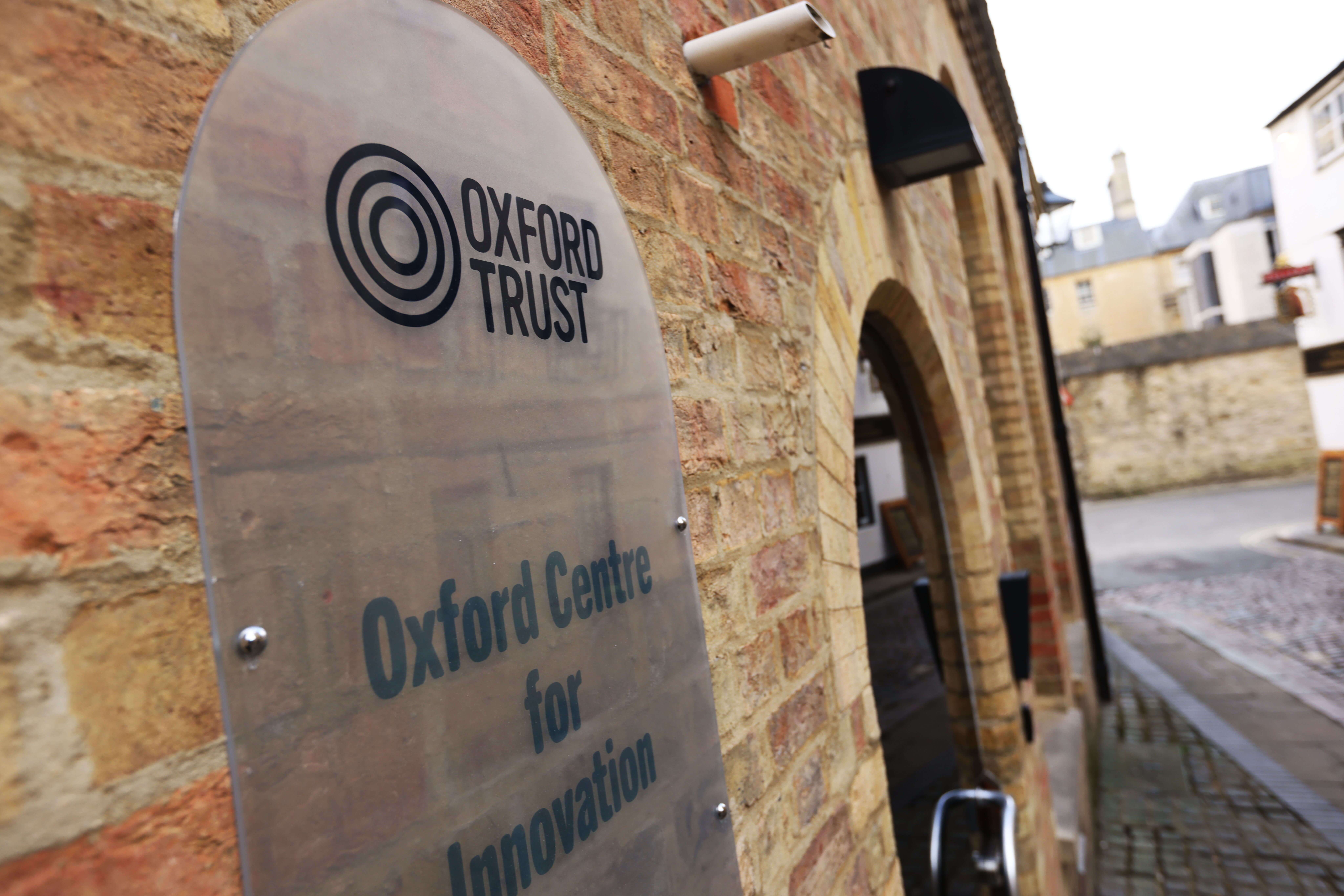 An exterior shot of the Oxford Centre for Innovation showing its building sign and the Oxford Trust logo.