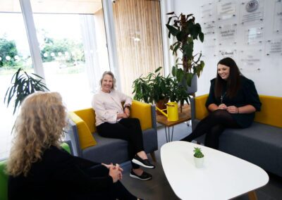 A team use the sofas for a meeting within the foyer area of the Wood Centre for Innovation.