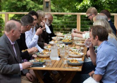 The Oxford Trust team eat a meal on the outdoor deck at the Wood Centre for Innovation.