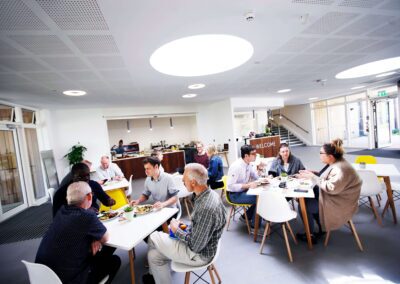 People eating lunch and having meetings within the foyer of the Wood Centre for Innovation